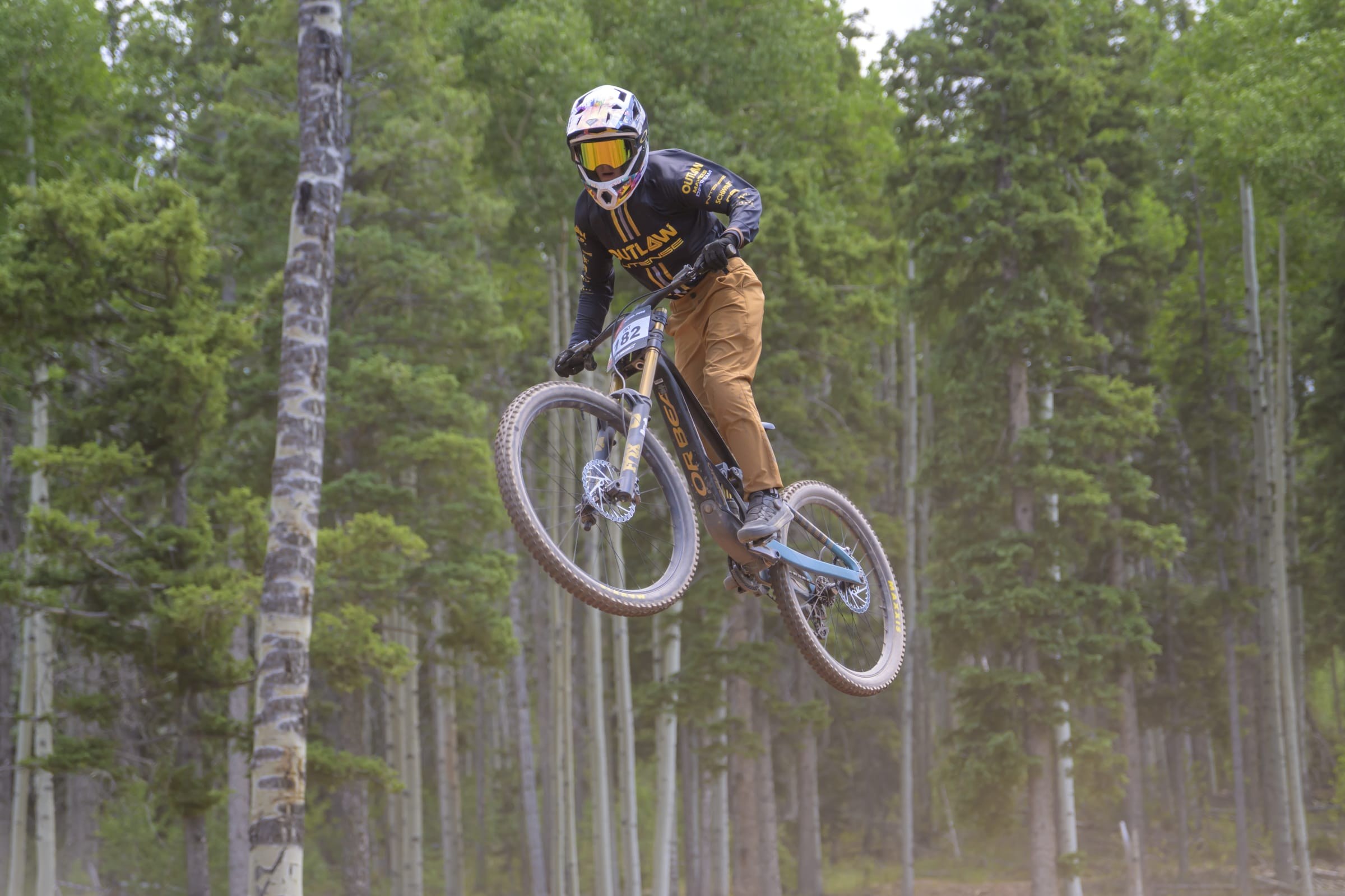 Rider airborne through the aspens at Angel Fire
